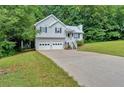 Attractive light-gray home with a two-car garage, surrounded by a lush green lawn and mature trees at 50 Old Oak Trce, Dallas, GA 30157