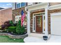 Elegant front entrance with stone accents, a stylish door, and mature landscaping at 971 Reap Ln, Lawrenceville, GA 30043
