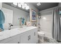 Cozy bathroom featuring tub and shower, marble vanity top, and white cabinets at 11352 Musette Cir, Alpharetta, GA 30009
