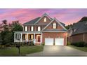 Beautiful two-story brick home with a two-car garage and manicured lawn at sunset at 1140 Promontory Drive, Marietta, GA 30062