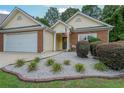 Charming single-story home featuring a well-manicured lawn and an attached two-car garage at 209 Diamond Valley Pass, Canton, GA 30114