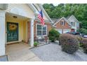 Inviting front porch featuring an American flag, bench, and decorative landscaping at 209 Diamond Valley Pass, Canton, GA 30114
