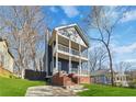 Attractive two-story home with a double front porch and brick foundation complemented by a lush green lawn at 2395 Saint James Nw Dr, Atlanta, GA 30318