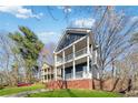 A charming two-story home featuring a double front porch, brick foundation, and an expansive front yard at 2395 Saint James Nw Dr, Atlanta, GA 30318