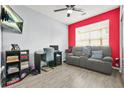 Living room space with gray sofa, dark wood desk and chair, and a red accent wall at 10 Perimeter Summit Ne Br # 2312, Atlanta, GA 30319