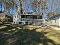 Home with a covered front porch and walkway, complemented by a green lawn, offers charming curb appeal at 1457 Richland Road Southwest Sw Rd, Atlanta, GA 30310