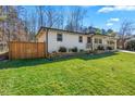Beautifully landscaped single-story home with lush green lawn, complemented by a privacy fence and mature trees at 5109 Dogwood Hills Dr, Sugar Hill, GA 30518