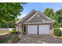 Charming brick home with a two-car garage and well-maintained landscaping and a manicured lawn at 2401 Centennial Hill Way, Acworth, GA 30102