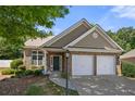 Charming brick home with a two-car garage and well-maintained landscaping and a manicured lawn at 2401 Centennial Hill Way, Acworth, GA 30102