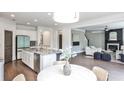Open-concept kitchen with granite countertops, white cabinets, stainless steel appliances, and seamless flow to living area at 11760 Stratham Dr, Alpharetta, GA 30009