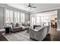 Inviting living room with hardwood floors, large windows, and neutral decor, adjacent to the kitchen at 11760 Stratham Dr, Alpharetta, GA 30009