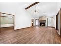 Open living room with a stone fireplace, wood beam, and hardwood floors, perfect for gatherings at 41 Ridgewood Cir, Mcdonough, GA 30252