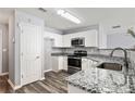 Well-lit kitchen featuring granite countertops, stainless steel appliances, and modern wood floors at 5446 Waterfall Ct, Atlanta, GA 30349