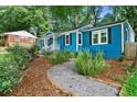 Charming blue home with a walkway, complemented by lush landscaping and stylish outdoor seating at 1718 Cahoon Sw St, Atlanta, GA 30310