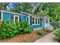 Charming blue home featuring black shutters and well-manicured landscaping at 1718 Cahoon Sw St, Atlanta, GA 30310