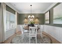 Elegant dining room with wainscoting, chandelier, and large windows for plenty of natural light at 48 Calla Dr, Douglasville, GA 30134