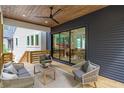 Relaxing covered porch featuring stylish outdoor seating and a view of the lush backyard at 160 Cedarwood Ln, Roswell, GA 30075