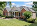 Beautiful single-Gathering home featuring well-kept landscaping and a cozy covered front porch with seating at 207 Breckenridge Ct, Canton, GA 30115