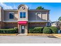 Inviting two-story townhome with classic brick facade, pink awning, and well-maintained landscaping at 3301 Henderson Mill Rd # X4, Atlanta, GA 30341