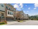 Beautiful townhome exterior showcasing brick facade, private garage, and well-kept landscaping at 2372 Se Montford Place Se Pl, Smyrna, GA 30080