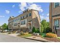 Brick townhome exterior, featuring well-maintained landscaping, a private garage, and a welcoming entrance at 2372 Se Montford Place Se Pl, Smyrna, GA 30080