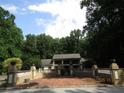 Exterior view of home featuring mature trees and a brick courtyard with decorative accents at 5523 Bahia Mar Cir, Stone Mountain, GA 30087