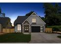 This charming two-story home has a stone-accented entrance, a garage with horizontal windows and a well-manicured lawn at dusk at 1780 Aircraft Se Dr, Marietta, GA 30060