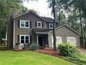 Two-story home with a front yard featuring lush landscaping and an attached two-car garage at 2105 Windy Oak Ct, Lithia Springs, GA 30122