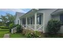 Inviting front porch with white railing, blue shutters, and landscaping, offering a cozy curb appeal at 4055 Haralson Mill Ne Rd, Conyers, GA 30012