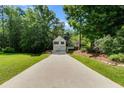 Charming two-story home featuring a long concrete driveway and lush surrounding foliage at 169 Knights Ct, Dallas, GA 30157