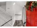 Bright entryway featuring a modern staircase, gray wood floors, and a vibrant red door at 634 Green Valley Dr, Smyrna, GA 30082