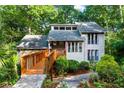 Inviting home featuring a wooden bridge entrance, stone accents, and mature trees providing plenty of shade at 634 Green Valley Dr, Smyrna, GA 30082