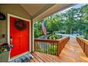 Inviting front porch featuring a bright red door, American flag, and wooden ramp at 634 Green Valley Dr, Smyrna, GA 30082