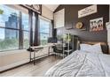 Modern bedroom with large window, desk, shelving, and black accent wall with white bedding for a bright space at 799 Hammond Dr # 427, Atlanta, GA 30328