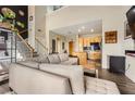 Open-concept living room featuring a gray sofa, wood floors, black accent wall and an adjacent kitchen with granite counters at 799 Hammond Dr # 427, Atlanta, GA 30328