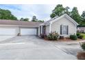 View of the home's side, featuring a two-car garage, driveway, and beautifully landscaped surroundings at 167 Camry Ln, Grayson, GA 30017