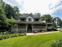 Inviting two-story house with a full wrap-around porch, offering a classic and welcoming facade at 3970 Governor'S Circle, Loganville, GA 30052