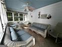 Relaxing screened porch with wicker furniture and ceiling fan, perfect for outdoor enjoyment at 3970 Governor'S Circle, Loganville, GA 30052