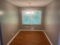 Cozy dining area with hardwood floors and a chandelier, illuminated by a large window at 273 Fennel Way, Atlanta, GA 30331