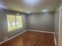 Bright living room featuring hardwood floors, recessed lighting, and a large window for natural light at 273 Fennel Way, Atlanta, GA 30331