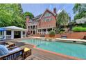 Amazing backyard pool with brick surround, a deck, and covered patio, ideal for outdoor relaxation at 320 Chason Wood Way, Roswell, GA 30076