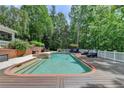 Beautiful backyard pool surrounded by lush greenery, with a spacious deck for lounging at 320 Chason Wood Way, Roswell, GA 30076