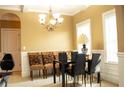 Elegant dining room features a stylish chandelier, comfortable seating, and ample natural light for gatherings at 1109 Norsworthy Ml, Hampton, GA 30228