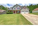 Charming home boasts a manicured lawn, attached garage, and a welcoming front porch perfect for relaxing at 524 Birchwood Dr, Temple, GA 30179