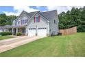 Well-maintained home showcasing a spacious lawn, an attached two-car garage, and a fenced yard at 524 Birchwood Dr, Temple, GA 30179