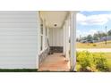 View of the covered porch featuring stone accents and a manicured lawn at 20 Tarpley Way, Covington, GA 30016