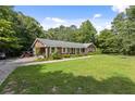 Sprawling brick ranch with a large front yard, mature trees, and a side-entry driveway at 1051 Rock Springs Rd, Lawrenceville, GA 30043