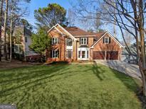 Beautiful brick home with well-manicured lawn, two car garage, and an inviting front entrance at 819 Bermuda Run, Woodstock, GA 30189