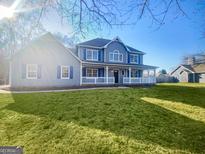 Charming two-story home features a welcoming front porch and well-manicured lawn at 225 Woodfield Ct, Mcdonough, GA 30253