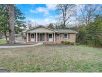 Charming brick home featuring a well-manicured lawn and a welcoming front entrance with a walkway at 3159 Nursery Se Rd, Smyrna, GA 30082